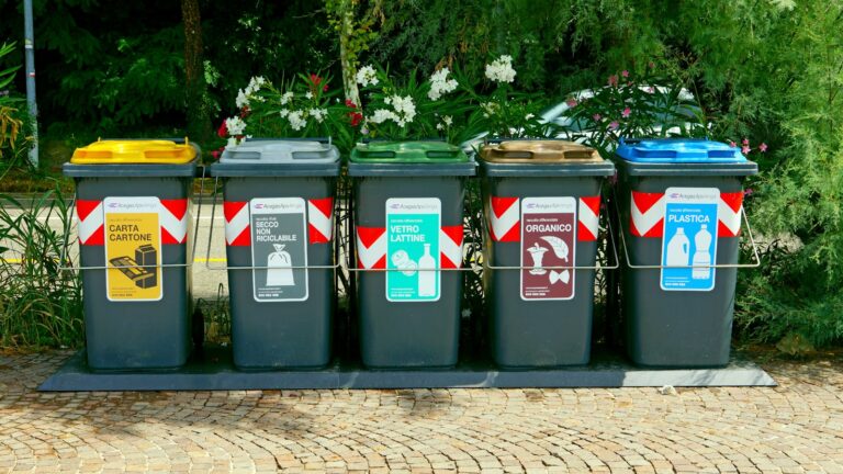 a row of trash cans sitting on top of a sidewalk